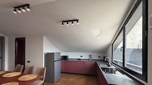 Een moderne keuken met een eethoek, een koelkast en een raam met uitzicht.