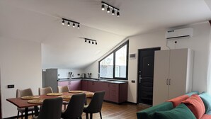 Een moderne keuken met een eethoek, een bank en een groot raam.