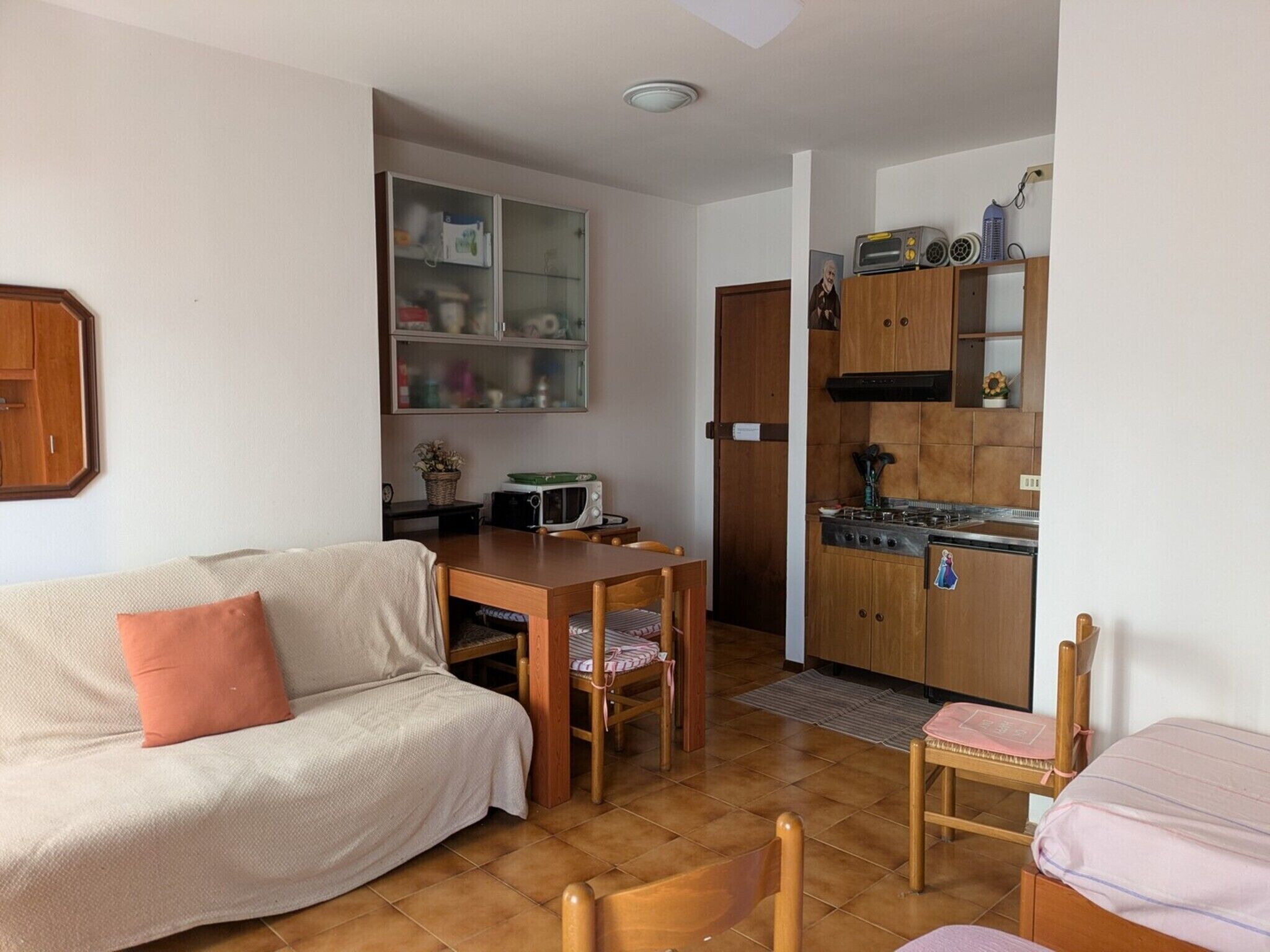 A compact living space with a sofa, a dining table, and a kitchenette.