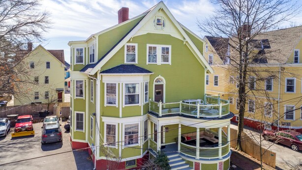 Ein mehrstöckiges Haus mit Balkon, Veranda und Garage.