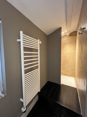 A room with a white radiator, a black floor, and a beige wall. - La Tannerie, village house in Avène (Avène)