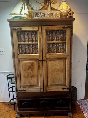 Un meuble en bois doté de portes en verre et d’une enseigne placée au-dessus.