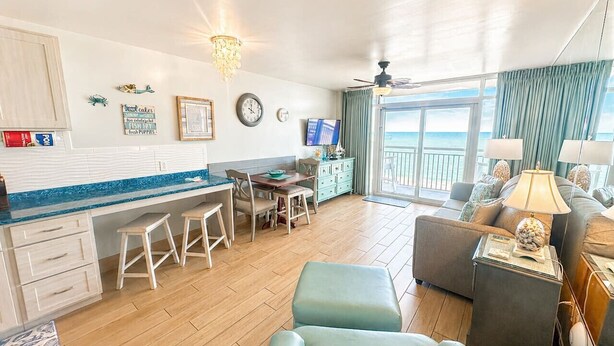 A spacious living area with a dining table, chairs, a sofa, and a TV. - Executive Pineapple Escape-Ocean View & Relaxation (Myrtle Beach)