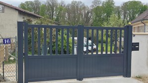 A gated entrance with a number sign, a concrete driveway, and a residential building in the background. - La Tiny de Lili A moment out of time. (Draveil)