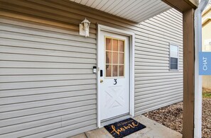 A house with a white door marked with the number 3, a small window, and a porch with a doormat. - Quiet 2bd room condo with beautiful scenery in the heart of Branson (Branson)