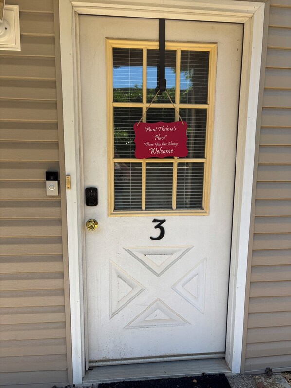 A white door with the number 3, a window with blinds, and a welcome sign. - Quiet 2bd room condo with beautiful scenery in the heart of Branson (Branson)