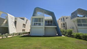 Um edifício moderno com design arquitetônico único, apresentando uma estrutura central com telhado inclinado e grande saliência.