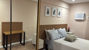 A bedroom with a bed, bedside table, nightstand, wall-mounted air conditioner, and framed artwork. - Modern apartment in Major Diogo: the heart of SP just a few steps away! (São Paulo)