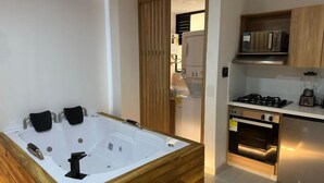 A modern kitchen with a built-in oven, microwave, and stove. - Apartamento con Jacuzzi Parque Guatape Antioquia (Guatape)