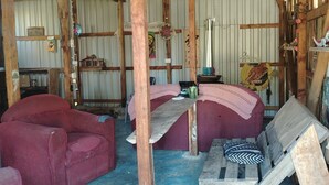 A rustic interior with wooden beams, a wooden bench, a red sofa, and a metal table. - Hippie Hut, Yoga and Relaxation (Paraiso)
