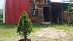 A two-story building with a red exterior and a wooden balcony. - Hippie Hut, Yoga and Relaxation (Paraiso)