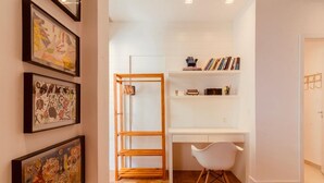 A room with a desk, chair, bookshelf, and framed artwork on the wall. - adv010 (Rio de Janeiro)