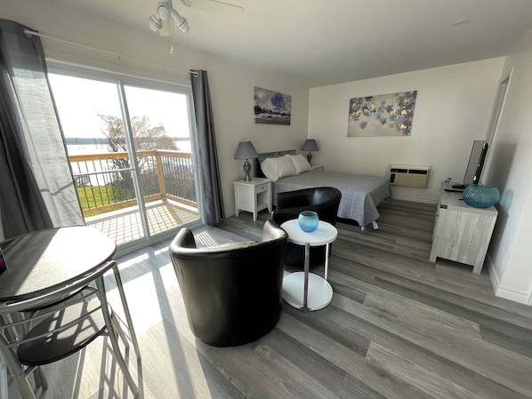 Una habitación de hotel moderna con balcón, cama, escritorio y silla.
