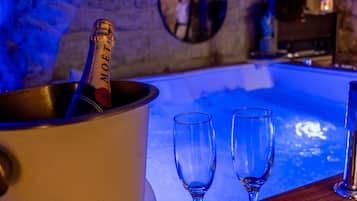 Een champagnefles in een emmer, twee lege glazen en een zwembad.