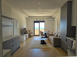Een moderne woonkamer met een bank, een eettafel en een televisie.