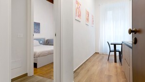 A room with a bed, a desk, and a chair, with artwork on the wall. - 'Ser Lapo - Dimora Ser Lapo' with Wi-Fi and Air Conditioning (Prato)