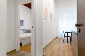 Ein Zimmer mit einem Bett, einem Schreibtisch und einem Stuhl, mit einem Kunstwerk an der Wand.