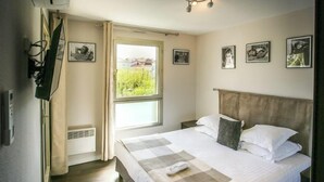 Una camera da letto con un letto, una finestra e quadri appesi al muro.