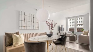 A modern living room with a sofa, round table, chairs, and artwork on the wall. - 17John: Superior 2 Bed W/D in unit + GYM + Lounge (New York)
