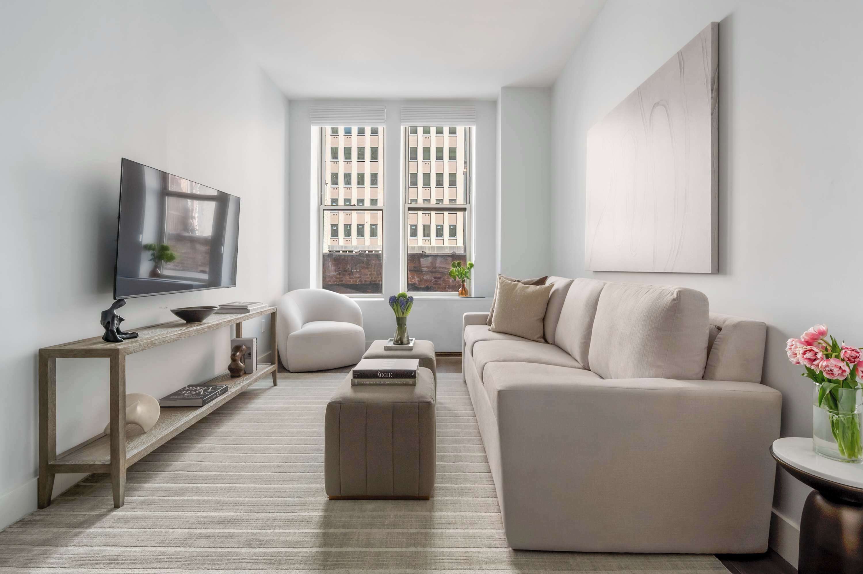 A modern living room with a sofa, a coffee table, a TV, and a bookshelf.