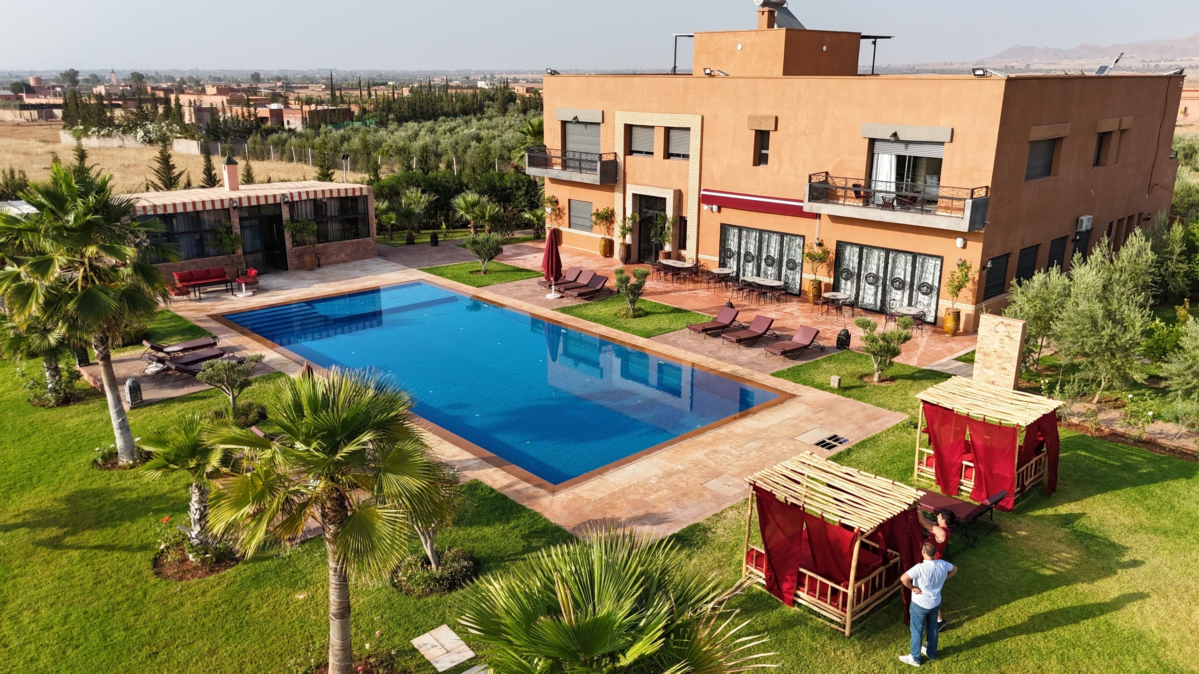 Un bâtiment moderne doté d’une piscine, d’un espace extérieur aménagé et offrant une vue sur le paysage environnant.