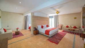 Ein geräumiges Schlafzimmer mit einem großen Bett, einem Sofa, einem Sessel und einem kleinen Tisch.