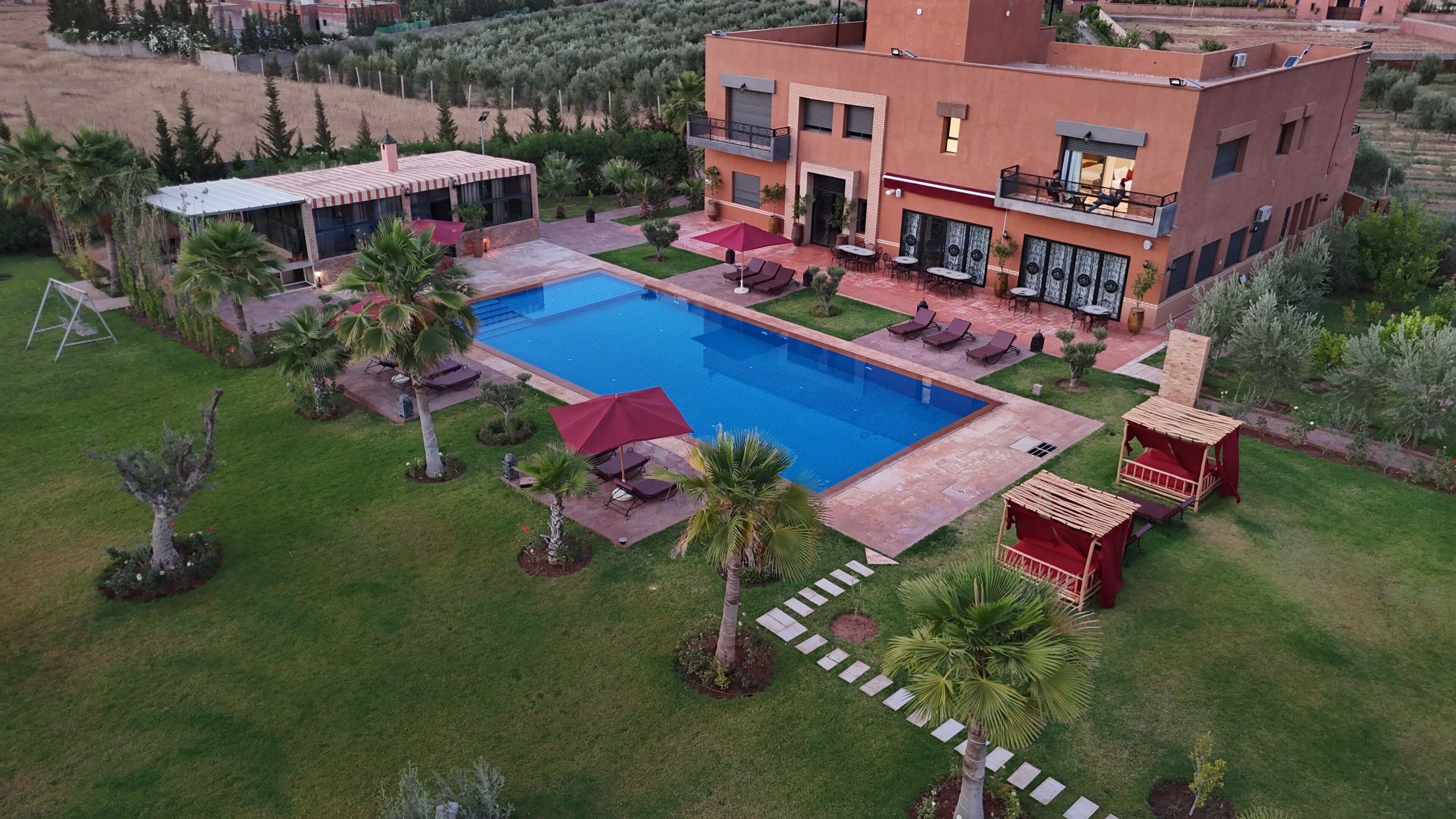 Propiedad residencial con piscina, zona de estar exterior y jardín.