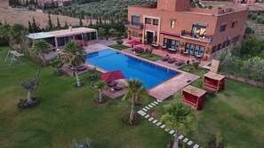 Propiedad residencial con piscina, zona de estar exterior y jardín.
