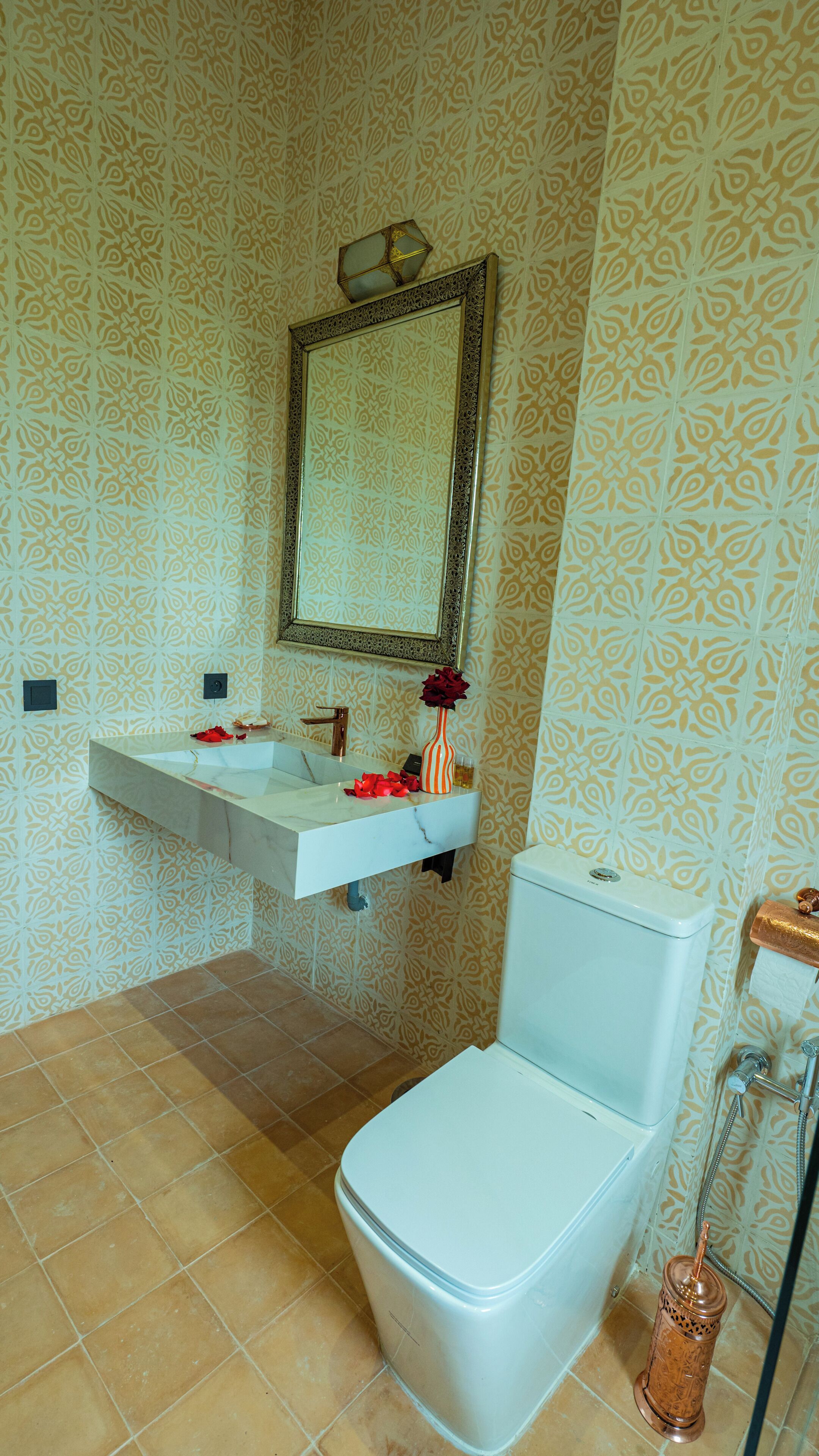 A bathroom with a toilet, sink, and mirror.