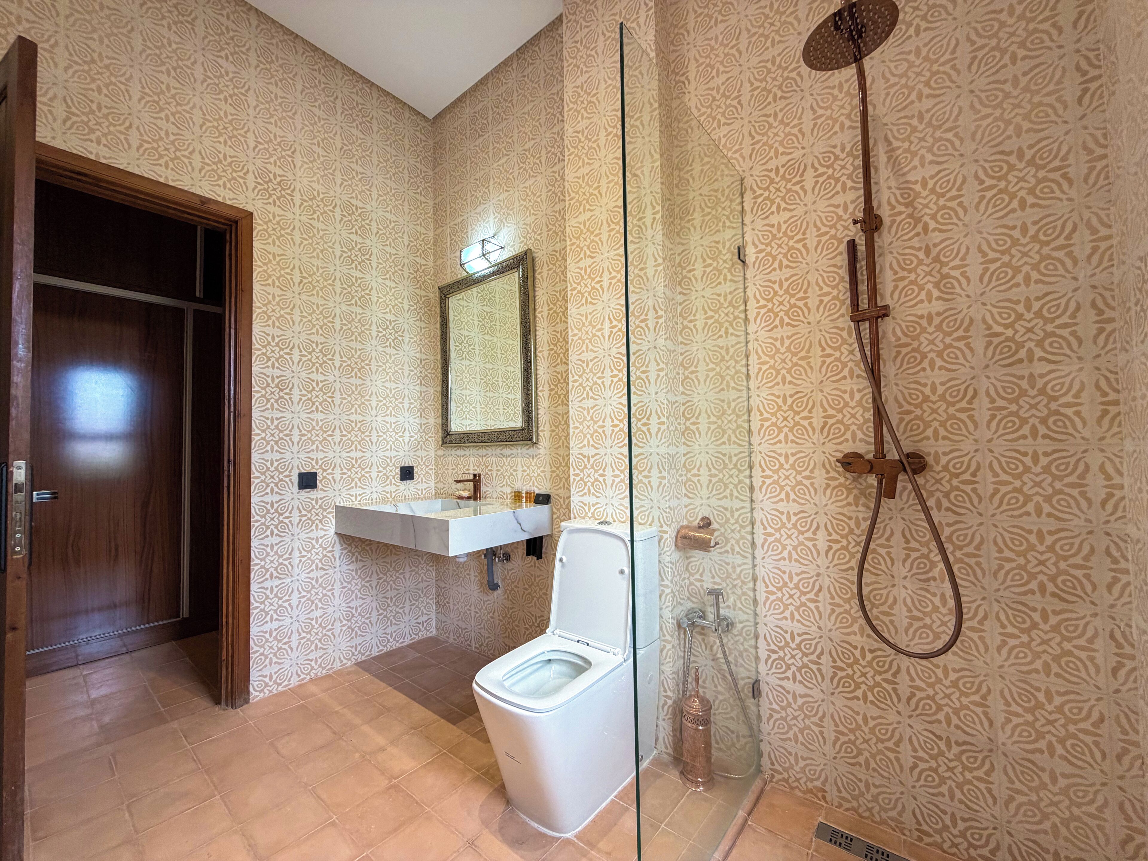 Un bagno con WC, lavandino, specchio e doccia.