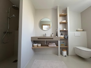 A modern bathroom with a shower, a sink with a mirror, and a toilet. - MODERN VILLA WITH POOL (Châtelaillon-Plage)