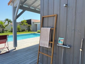 A wooden deck with a pool, a towel on a wooden ladder, and a welcome sign. - Modern villa with a pool (Châtelaillon-Plage)