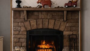 A fireplace with a stone surround, a mantel with decorative items, and a cow figurine. - Amazing 3-bedroom home in charming O'Brien Florida (O'Brien)