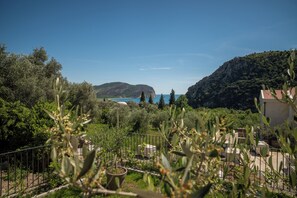A view of a coastal landscape with a mountain, trees, and a building with a red roof. - Villa Elysium (Petrovac)