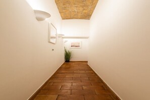 Ein Korridor mit Terrazzoboden, weißen Wänden und Stein Decke.