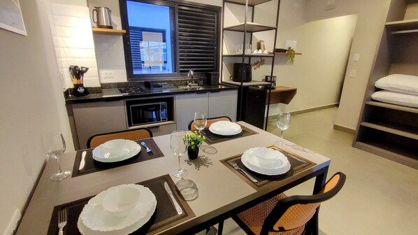 A modern kitchen with a dining area set for four. - Airport Residence (Guarulhos)