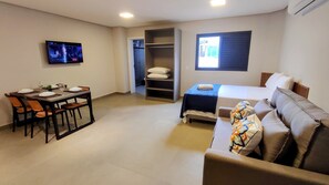 A compact hotel room with a dining area, a bed, and a TV. - Airport Residence (Guarulhos)
