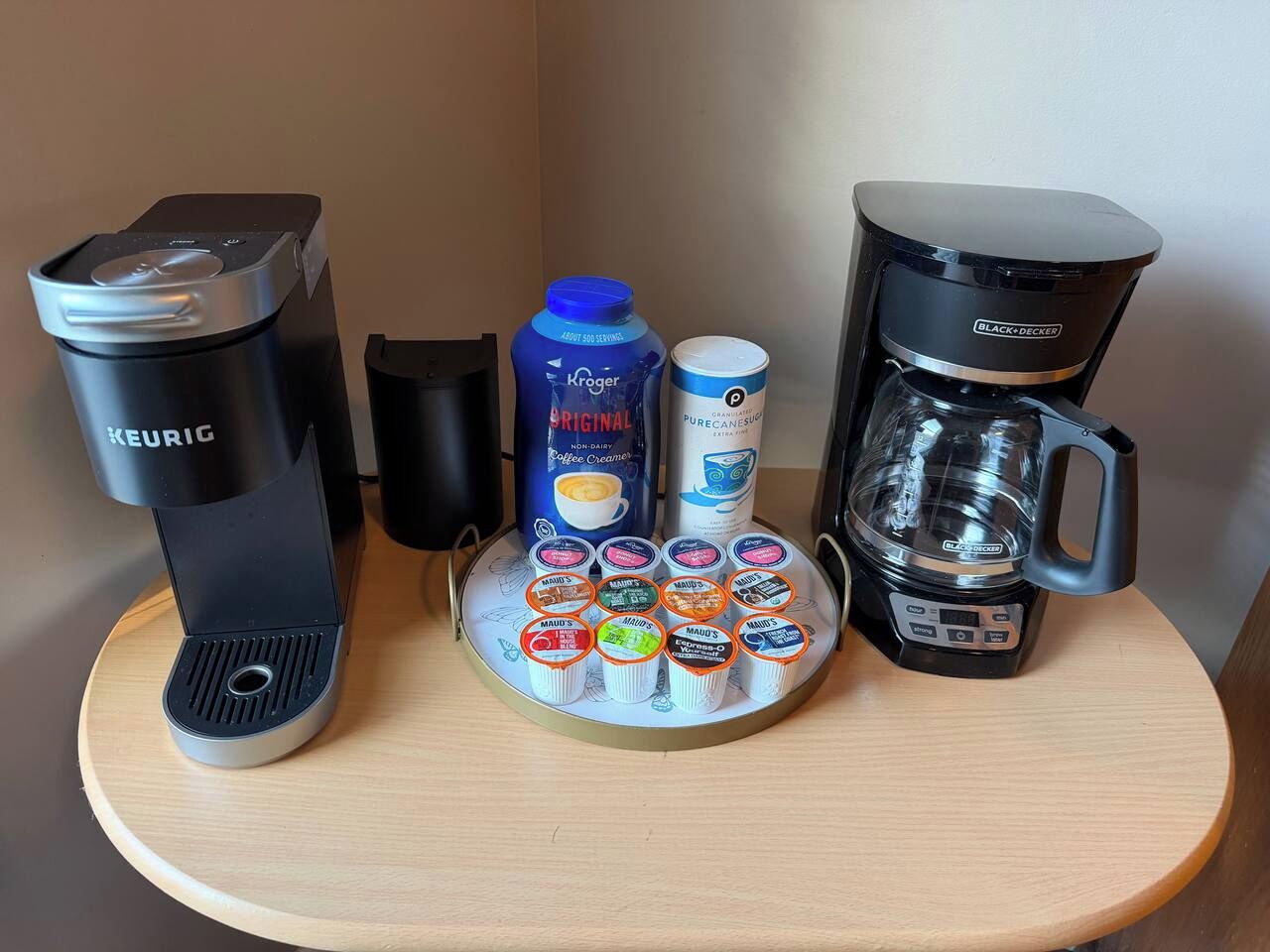 Una estación de café con dos cafeteras, un espumador de leche y una variedad de tazas para leche condensada.