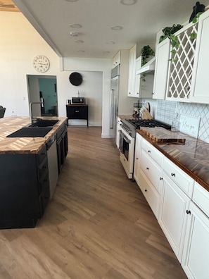 A modern kitchen with a central island, white cabinetry, and a wooden floor. - BEST view in the whole town- private sanctuary. (Sturgis)