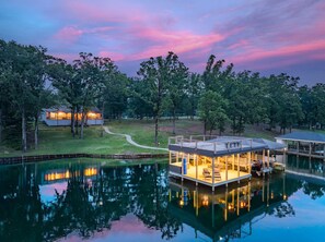 A lakeside property with a house, a dock, and a boat house.