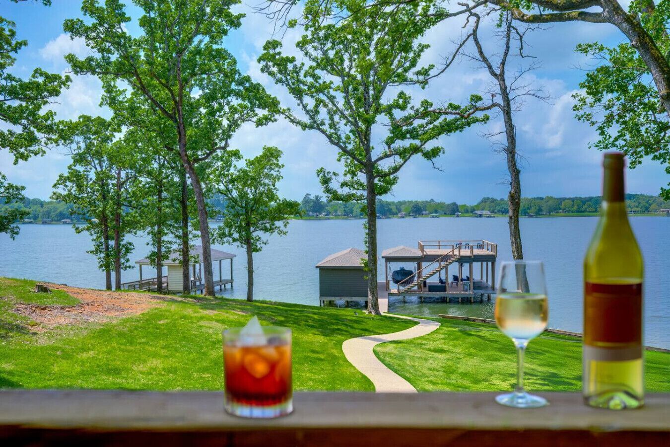 A lakeside view with a dock, a gazebo, and a grassy area.