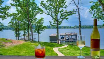 A lakeside view with a dock, a gazebo, and a grassy area.