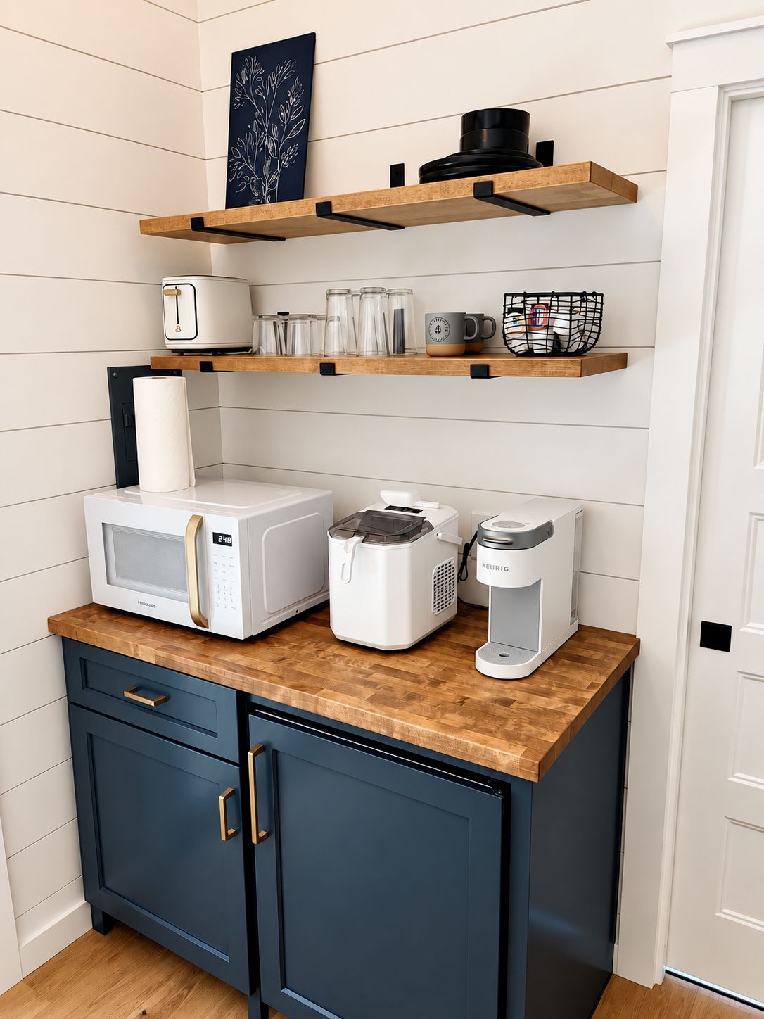 A kitchen with a microwave, coffee maker, and storage shelves.