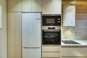 A kitchen with a refrigerator, microwave, oven, and a ventilation hood. - Chios Comfort Home D2 (Chios)
