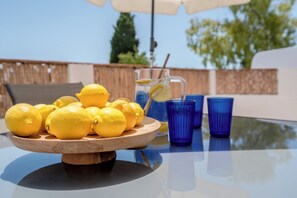 A table with a wooden bowl of lemons, a pitcher with a straw, and blue glasses. - Boho Beach House, artist residence, steps from the sand (Luz)