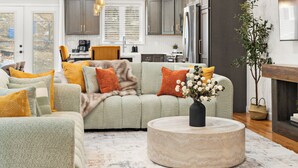A modern living room with a sofa, coffee table, and a plant.