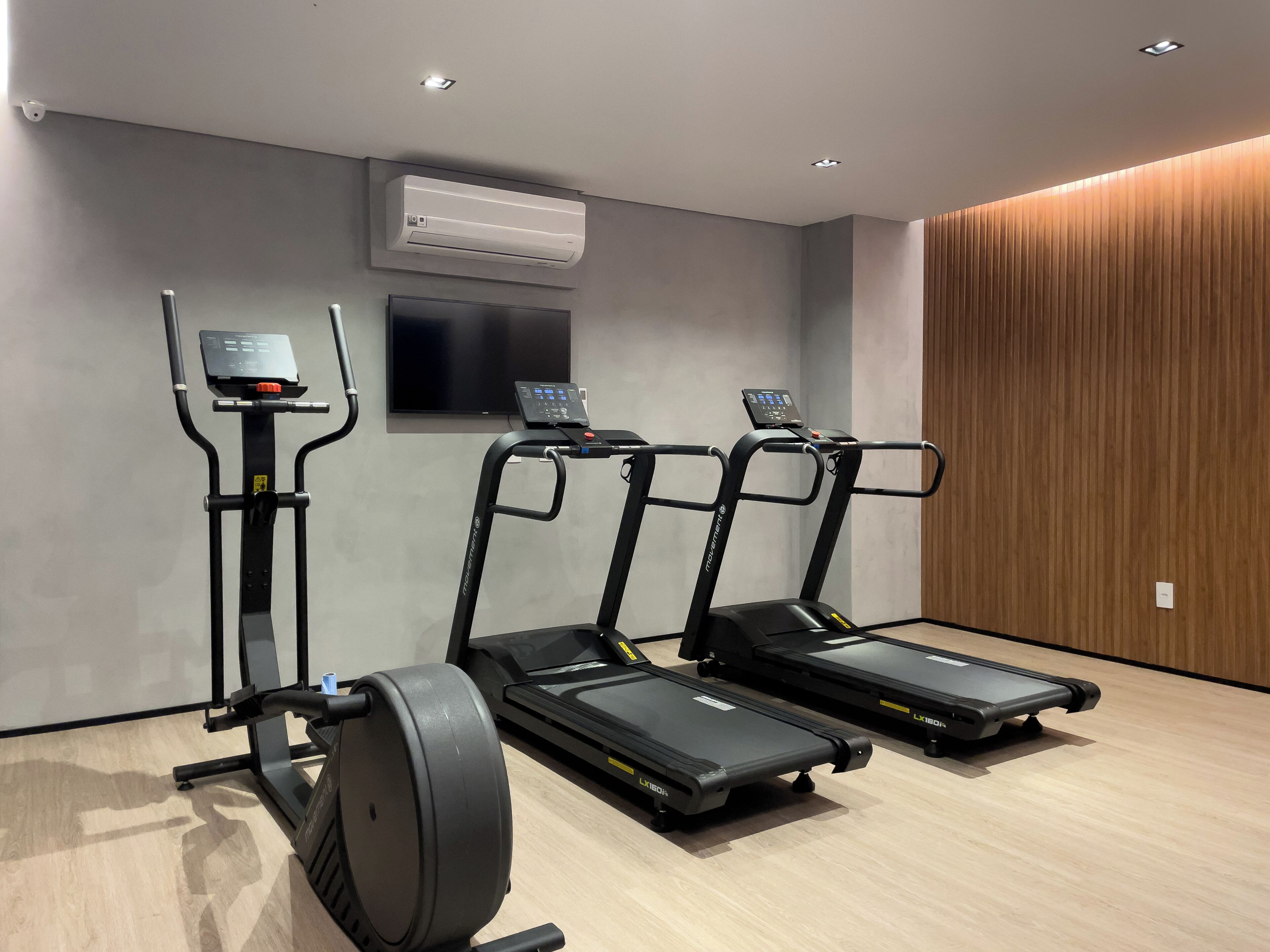 A gym with treadmills, an elliptical, and a stationary bike.