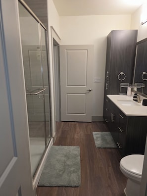 Un baño moderno con ducha, inodoro y tocador.
