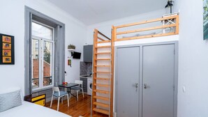 Une petite pièce comprenant un lit, un bureau, un lave-linge et une armoire.