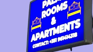 Un panneau indiquant « PALMA ROOMS & APARTMENTS » avec les coordonnées.